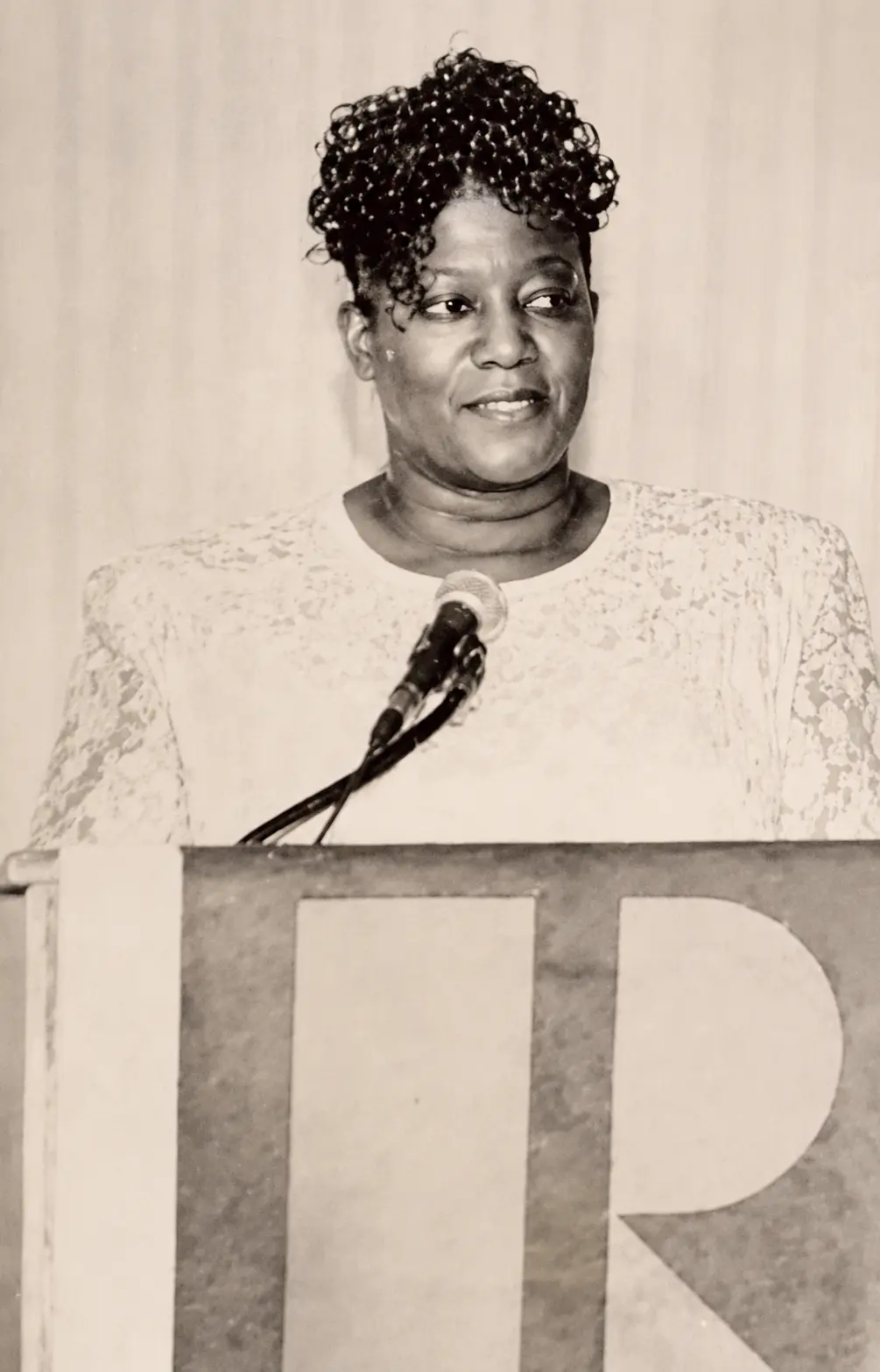 Historic portrait of Mae Dixon speaking at a podium